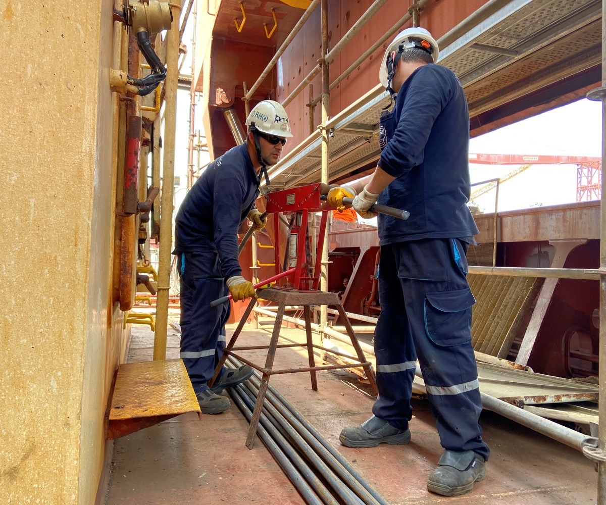 Two Bravo Ship team members collaborate on a project aboard a vessel, showcasing the company's dedication to delivering tailored technical solutions with precision and expertise.