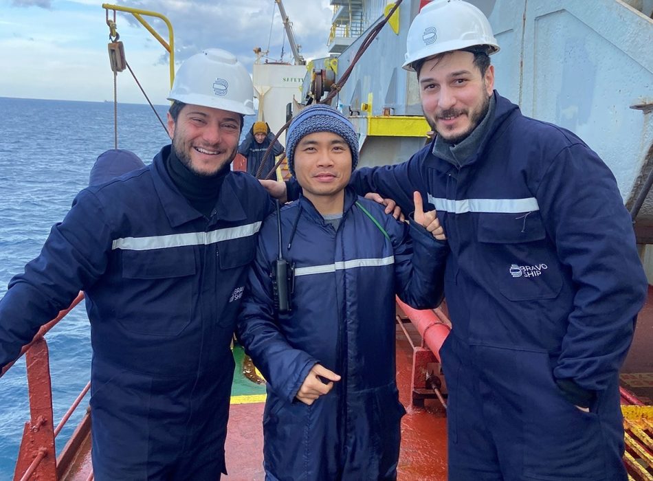 Two Bravo Ship team members and the vessel's superintendent pose for a photo on the vessel's deck, reflecting the spirit of collaboration and successful project completion.