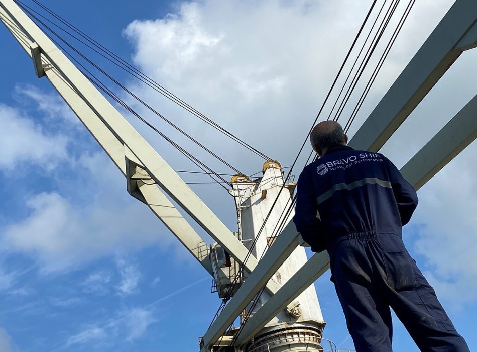 A Bravo Ship technician inspects a vessel's general-use crane, showcasing Bravo Ship's expertise in providing top-notch technical solutions.