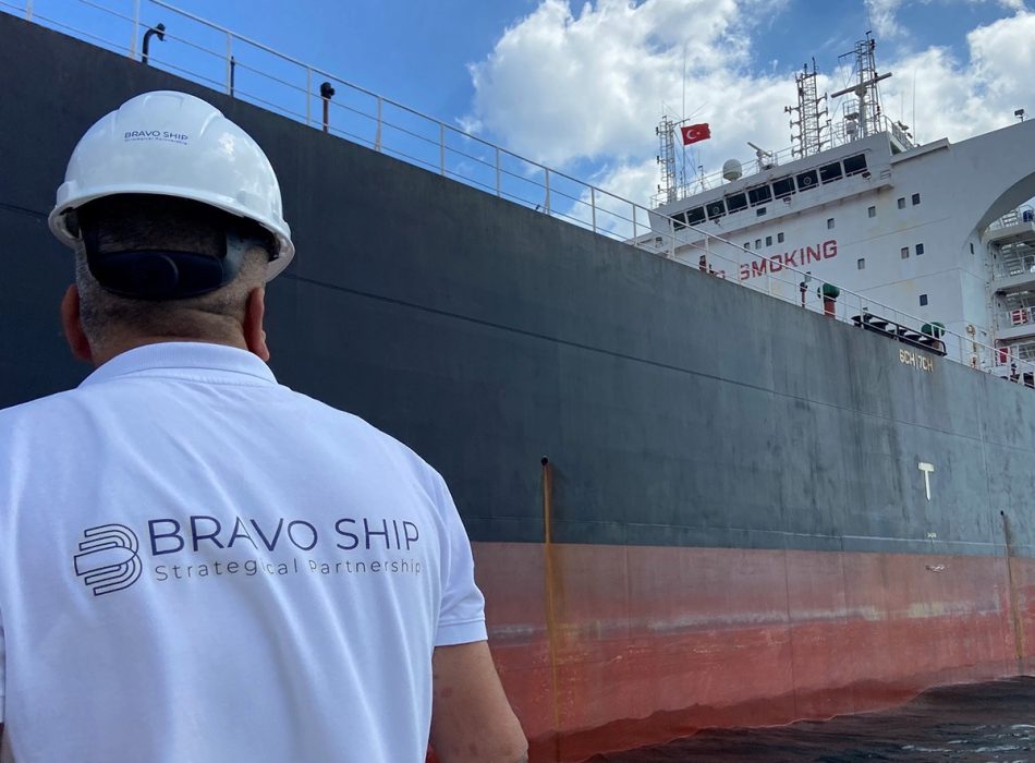 A Bravo Ship crew member on a motorboat prepares to embark onto a vessel at sea, exemplifying Bravo Ship's dedication to seamless maritime operations.