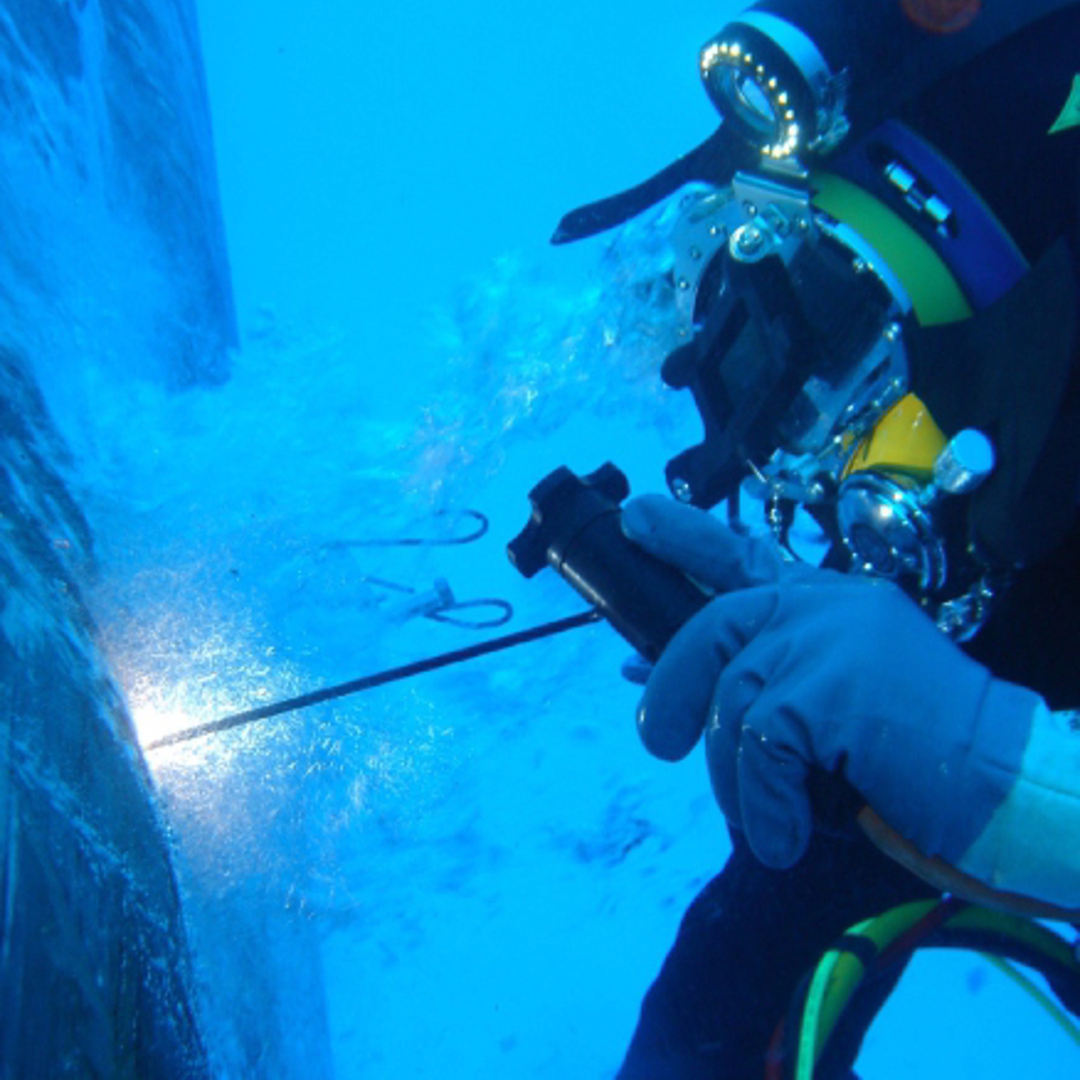 Underwater repair operation performed by professional diver inspecting and welding vessel hull in Istanbul waters.